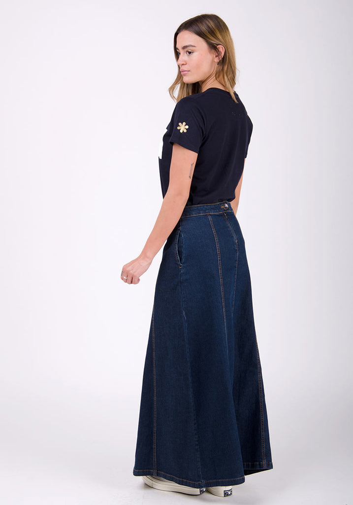 Angled side full-length shot of panelled denim maxi skirt showing side pocket, back zip and button fastening.