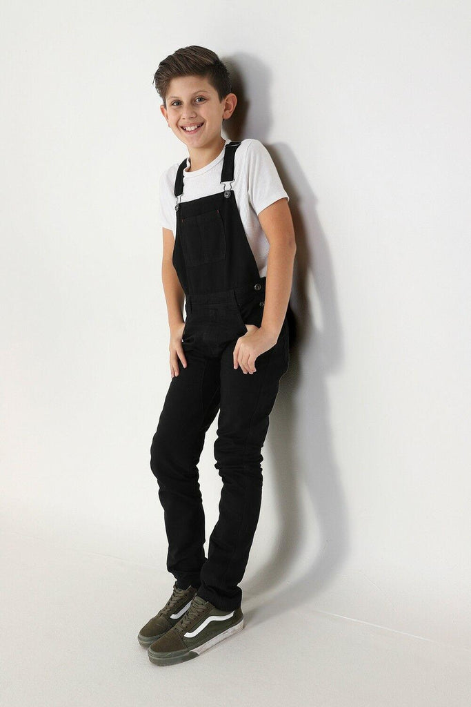 Full length side-view of boy with hands in pockets wearing Matthew-style slim-fit overalls from Dungarees Online.