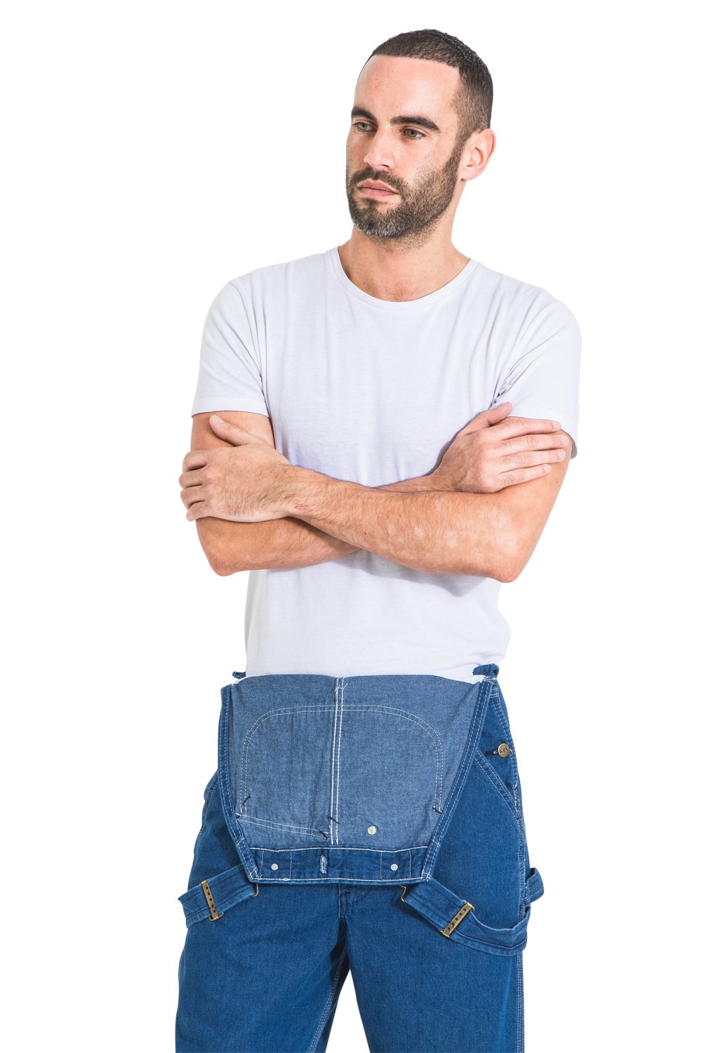 Top-half frontal view of model wearing ‘Key Apparel USA ’relaxed-fit, stone wash bib-overall with bib down, revealing white t-shirt.
