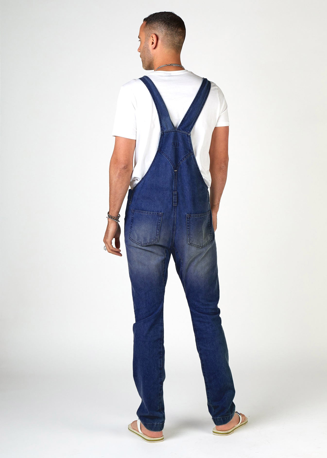 Full rear view of pure cotton bib overalls for men clearly showing back straps and pockets.