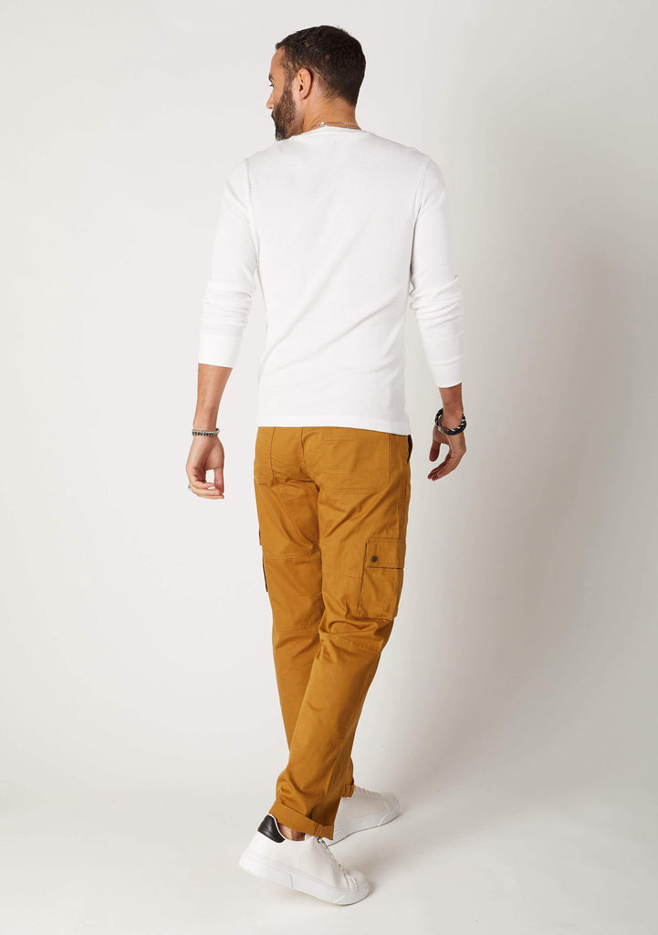 Back view of gold-brown, organic cotton combat trousers paired with white cotton sweater.