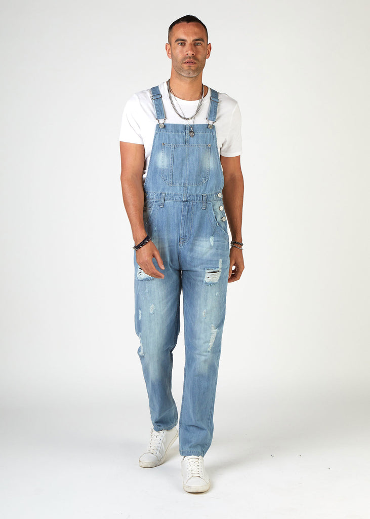 front, full-length walking pose, wearing loose, palewash, ripped denim dungarees.