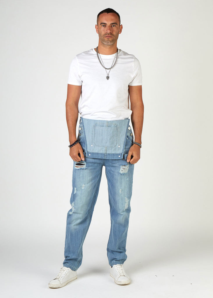 Full-length front with bib down revealing white t-shirt. Wearing 'Bertie' brand relaxed fit palewash ripped dungarees from Dungarees Online.