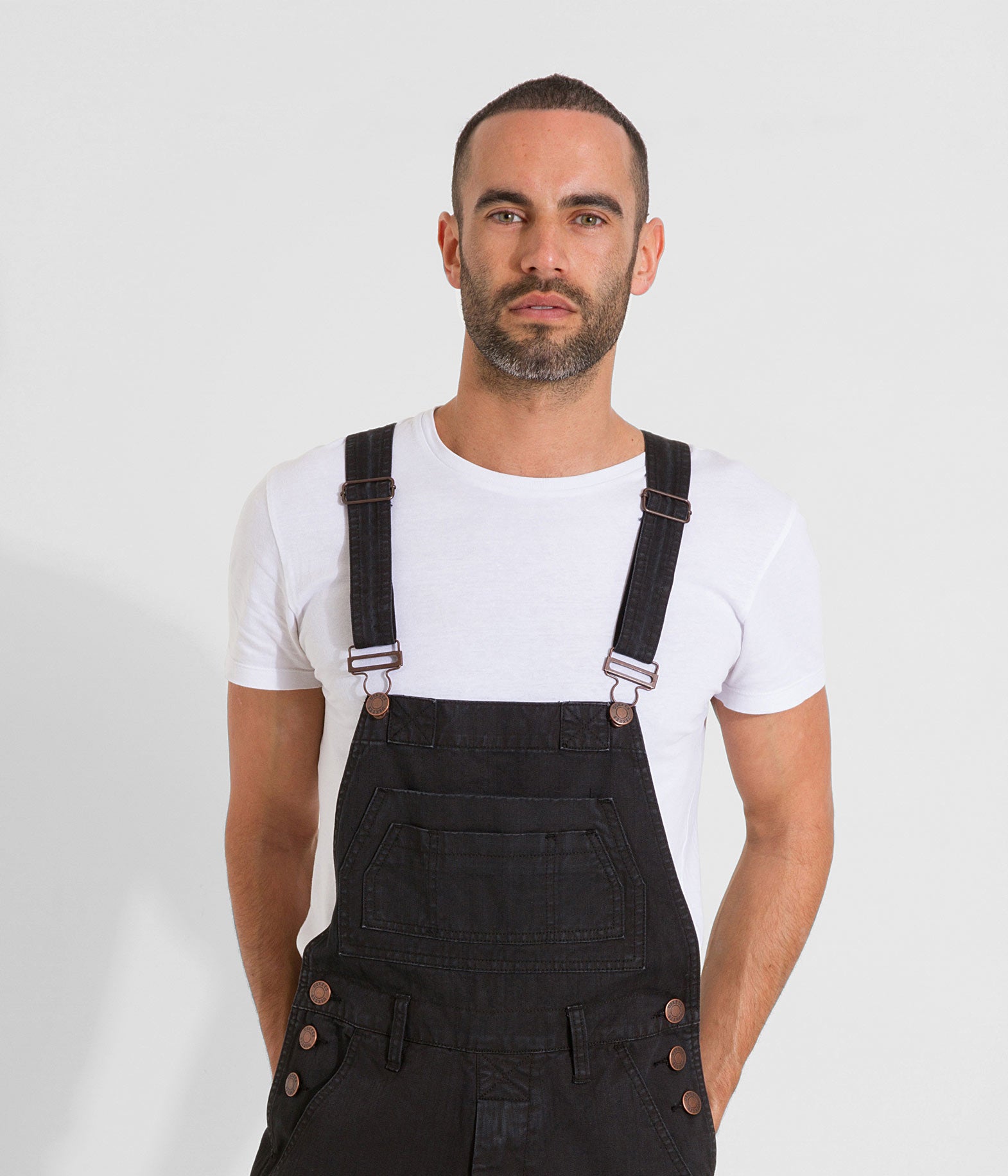 Top-half front view, looking ahead with view of adjustable straps and multiple pockets on relaxed Maddox dungarees.