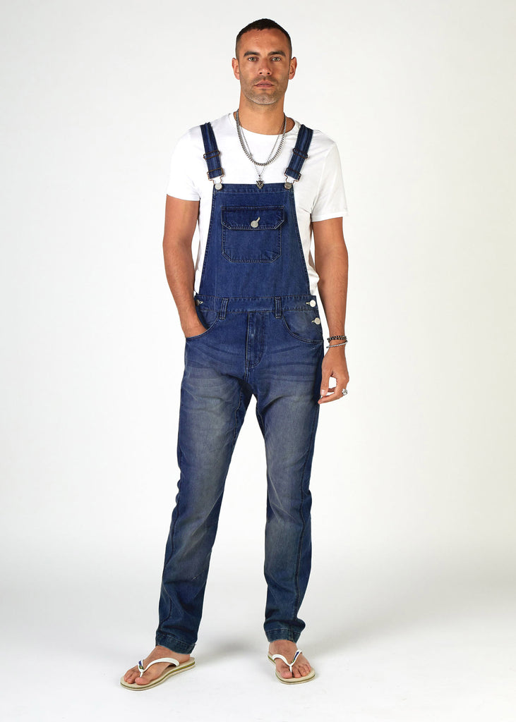 Full front pose with hand in right pocket, wearing Slim Fit denim bib-overalls with a tapered leg from Dungarees Online.