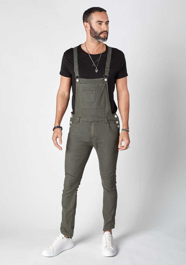 front pose looking left with bib up wearing mid-green, 'Burton' style skinny fit dungarees.