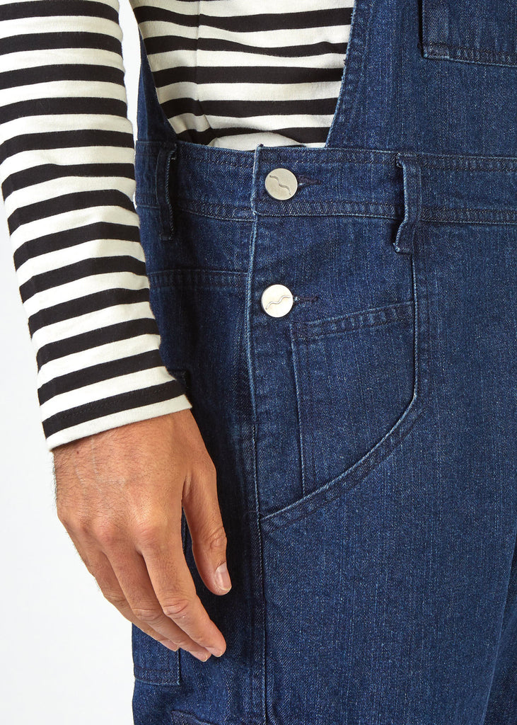Close-up side view of relaxed-fit 'Lee' bib-overalls with view of side pockets, belt loops and side button fastenings.