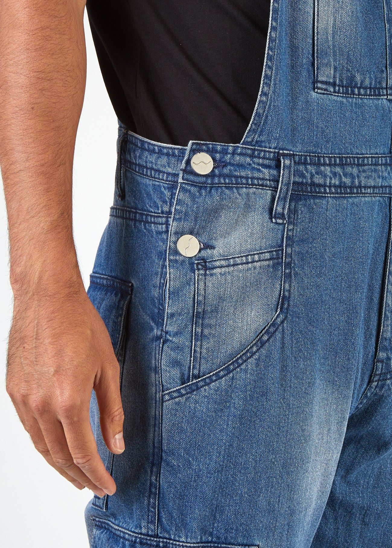 Close-up side view of relaxed-fit 'Lee' bib-overalls with view of side pockets, belt loops and side button fastenings.