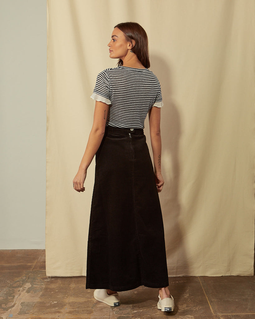 Full-length angled back view of Lottie black cord maxi-skirt showing back zip.