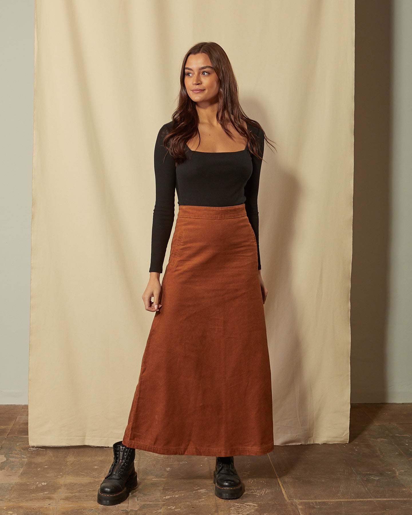 Full-length front view of model wearing Lottie brown corduroy maxi-skirt demonstrating A-line silhouette.