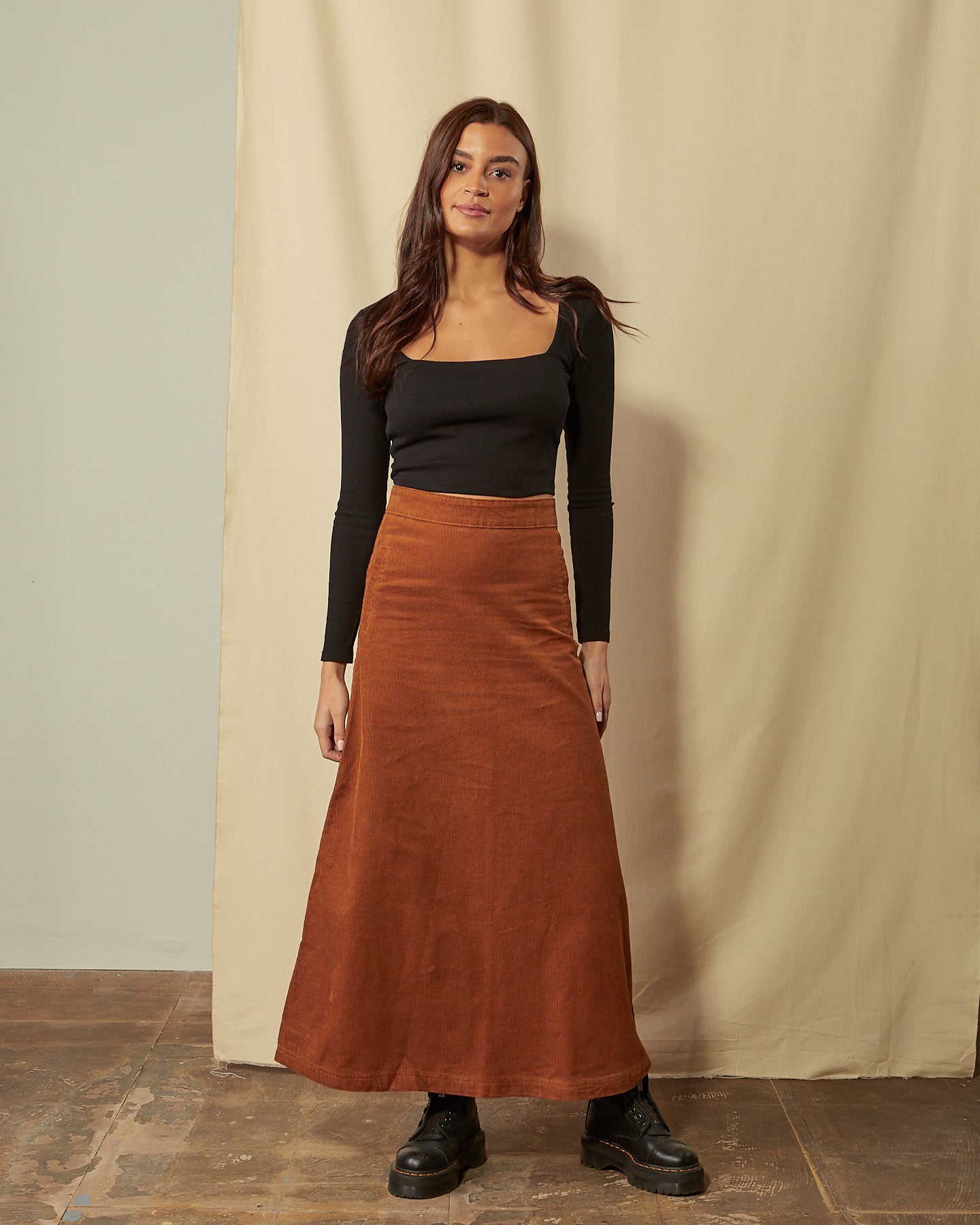 Full-length front view of model wearing Lottie brown corduroy maxi-skirt demonstrating A-line silhouette.