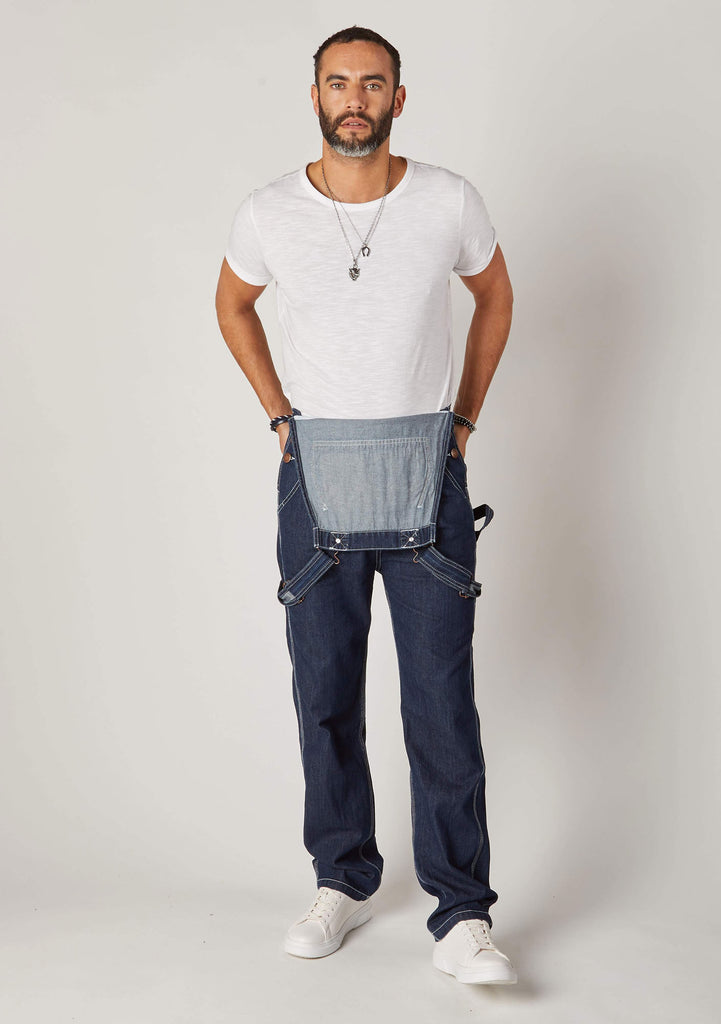 Front view of dark blue dungarees, styled with bib-down revealing white t-shirt and bib lining.