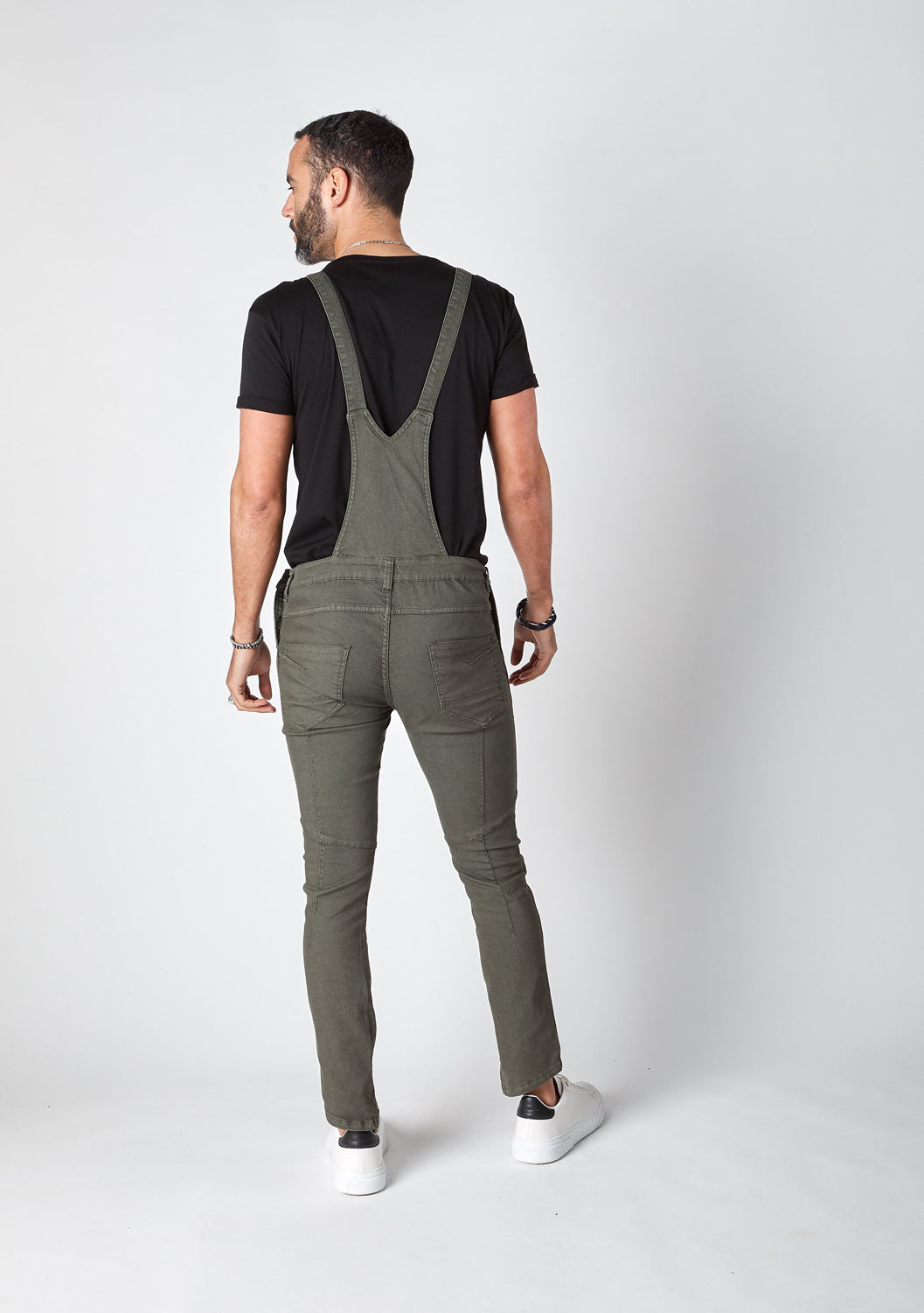 Rear pose wearing mens skinny fit dungarees with focus on cross straps.