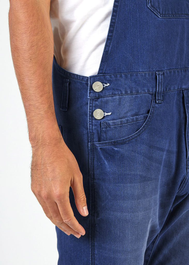 Mid view of 'Bruce' blue denim dungarees, clearly showing 2-button side fastening and side pockets.