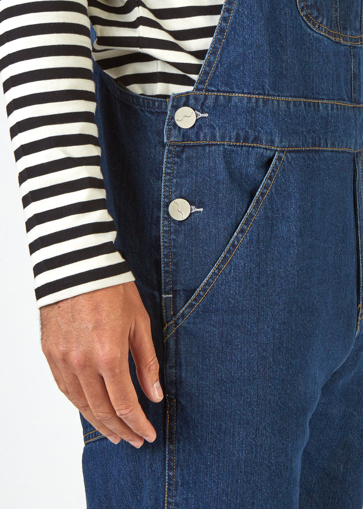 Close-up side view of 'Dave' bib-overalls with view of side pockets and side button fastenings.