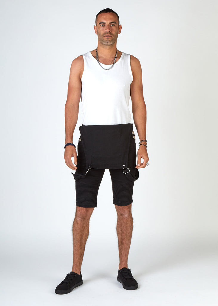 Full-length front pose of model weraing mens black biker dungaree shorts with bib down