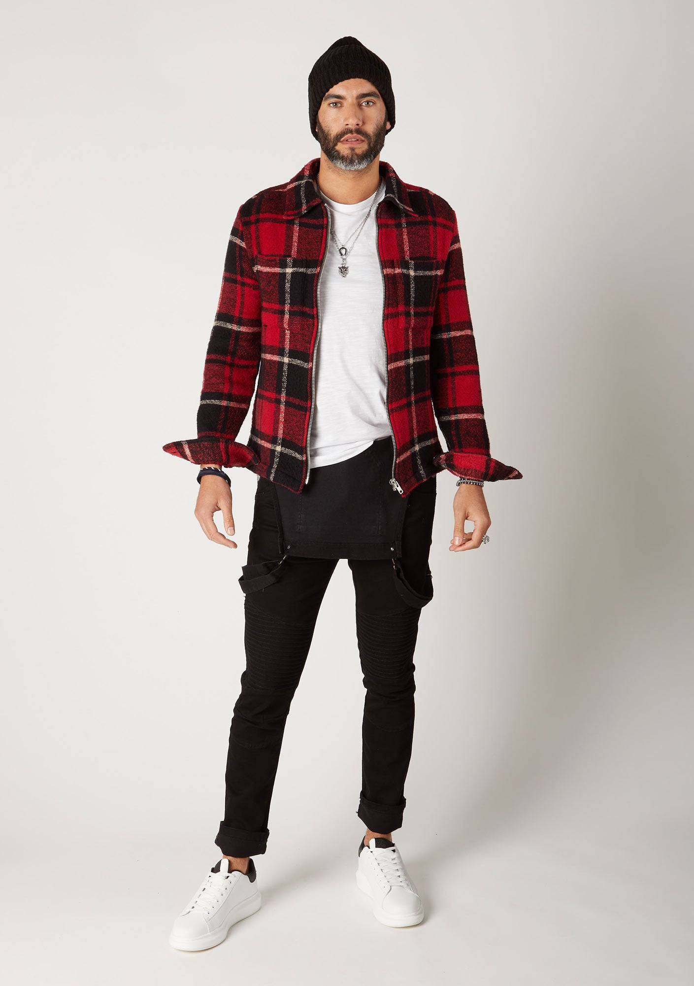 Front shot men's skinny fit black denim bib-overalls, styled with bib down paired with red check jacket.