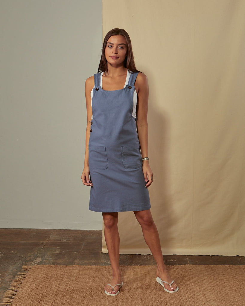 Full-length front view of model wearing sleeveless Addie muted blue organic cotton pinafore.