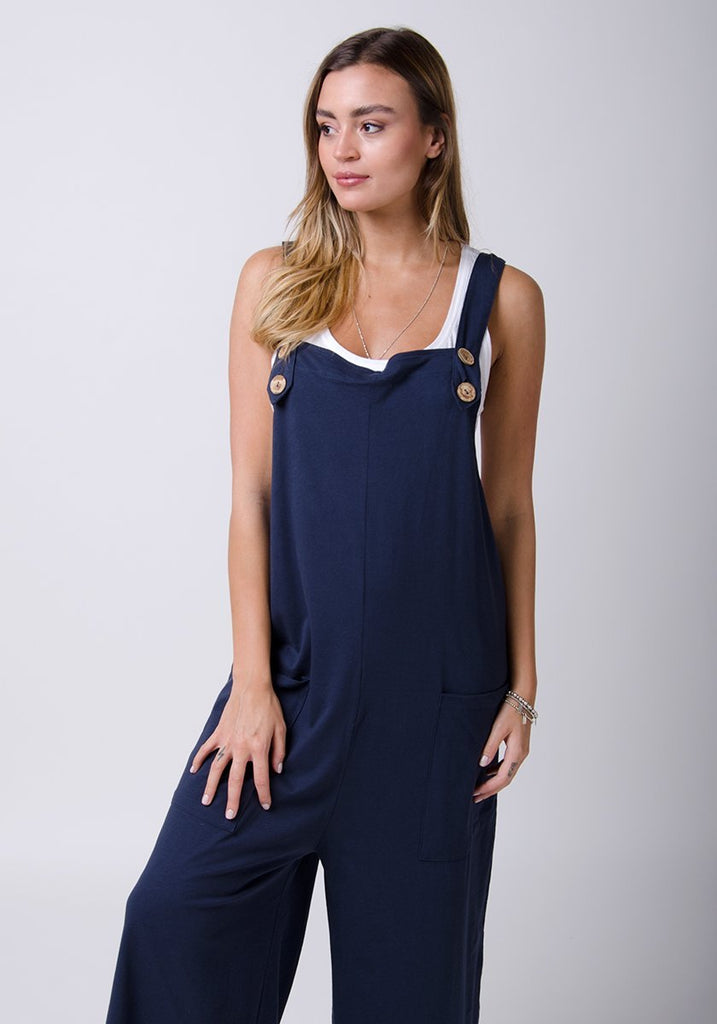 Amber-style, navy cotton jersey, wide-leg dungarees. Two-thirds length pose with hands on pockets.