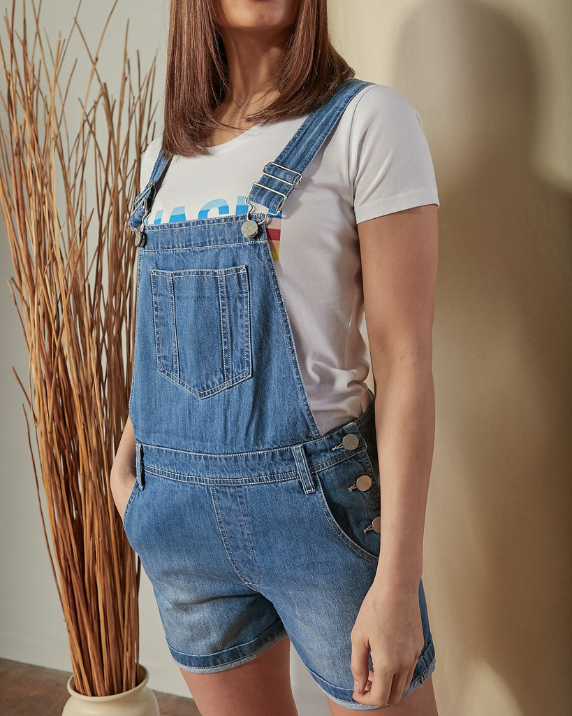 Mid view of Ava denim dungaree shorts with focus on bib pocket, adjustable straps and belt loops.
