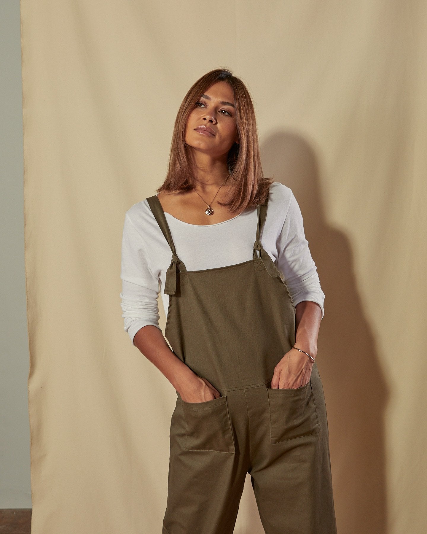 Close up of loose fit Catherine dungarees with clear view of the tie shoulder straps and front pockets.