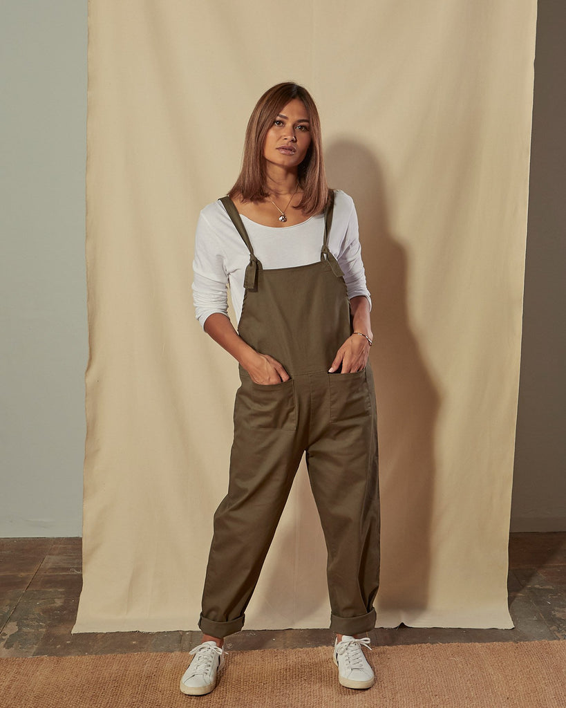 Full-length front view of model with hands in front pockets of Catherine khaki cotton twill dungarees.