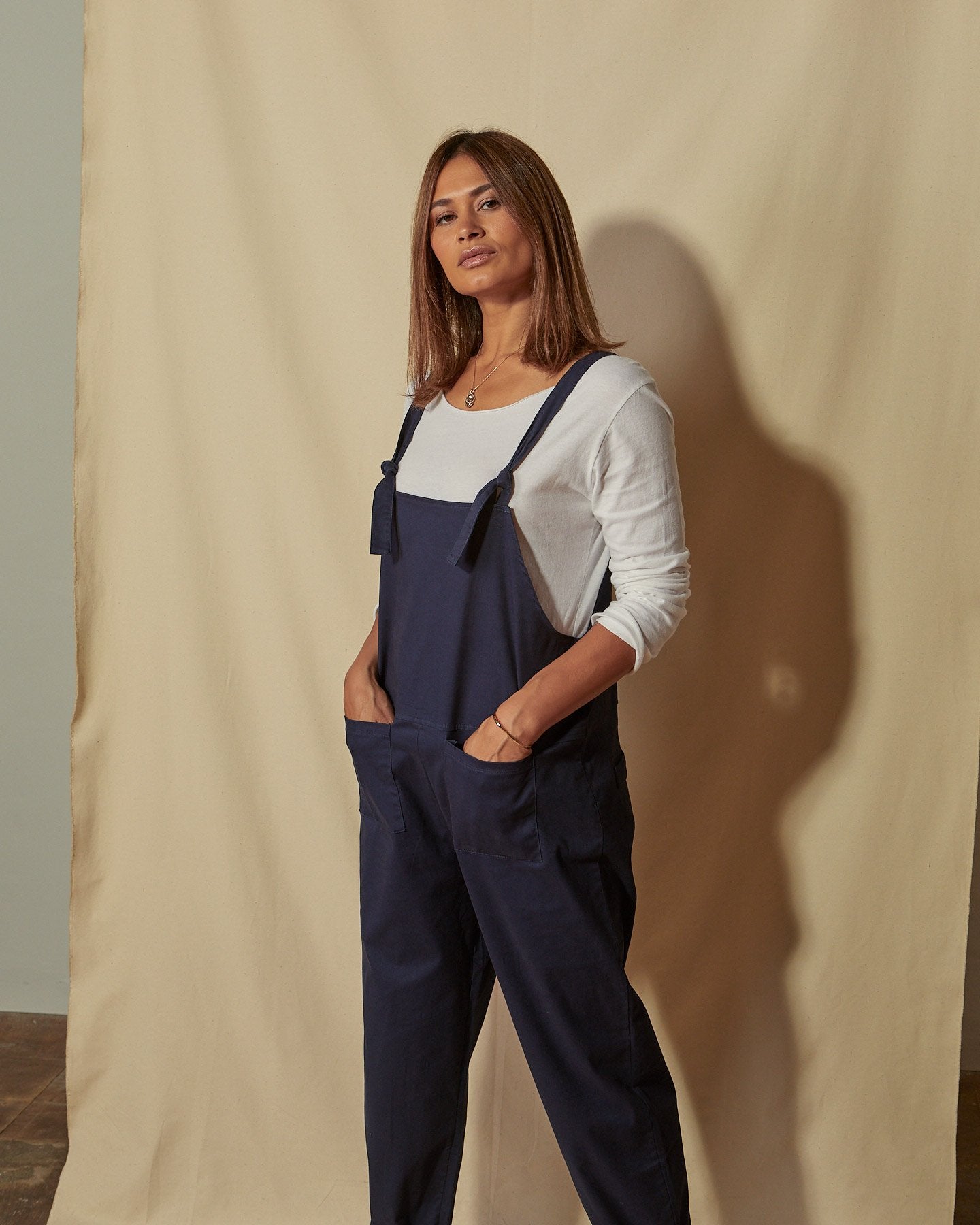 Front three quarters view of loose fit Catherine dungarees with clear view of the tie shoulder straps and front pockets.