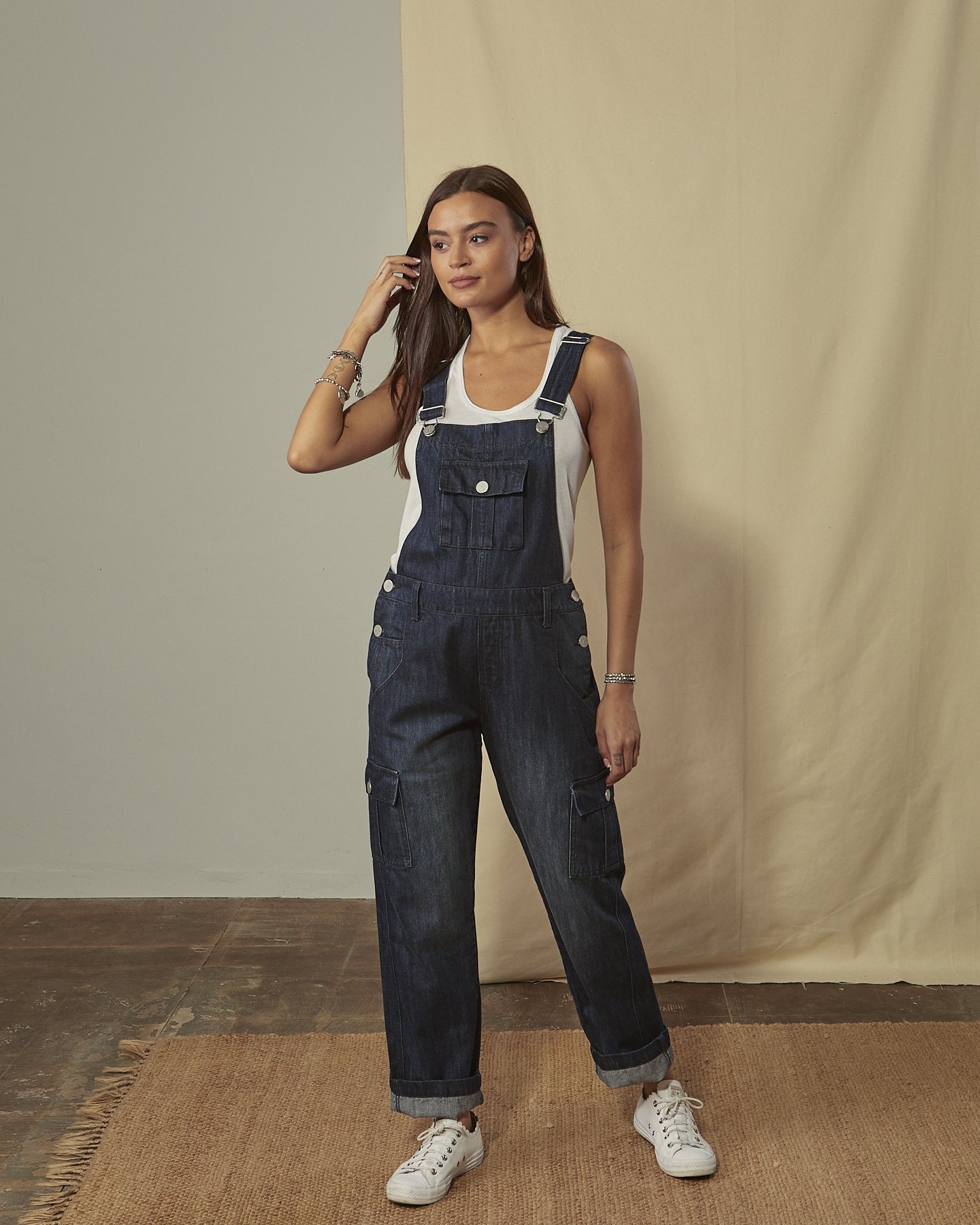 Front shot of Daphne darkwash denim dungaree with legs slightly rolled up with view of front, cargo & bib pockets.