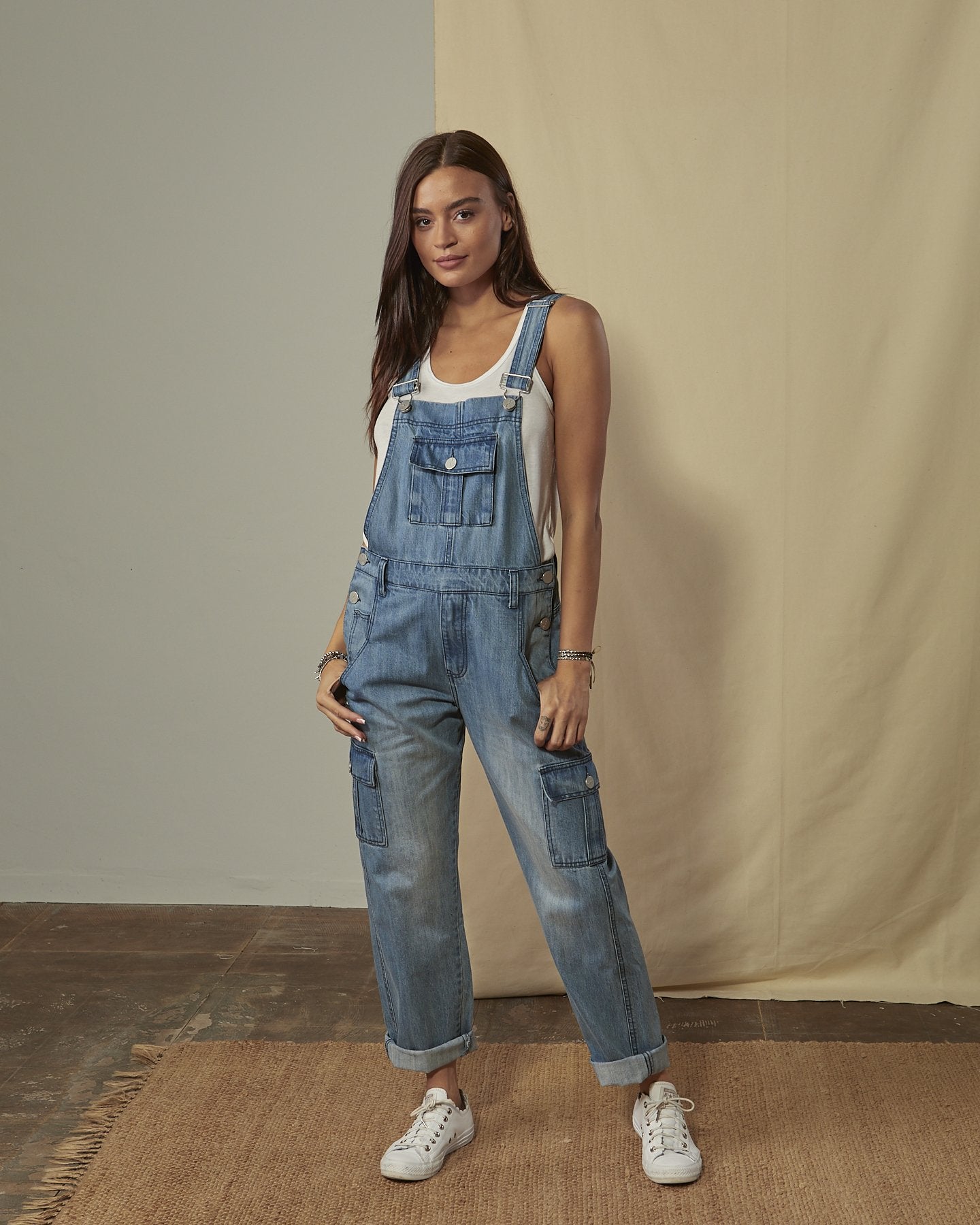 Front shot of Daphne stonewash denim dungaree with legs slightly rolled up with view of front, cargo & bib pockets.