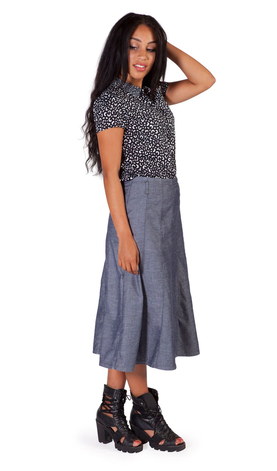 Full length side shot of calf-length dark chambray denim panelled skirt with view of belt loops.
