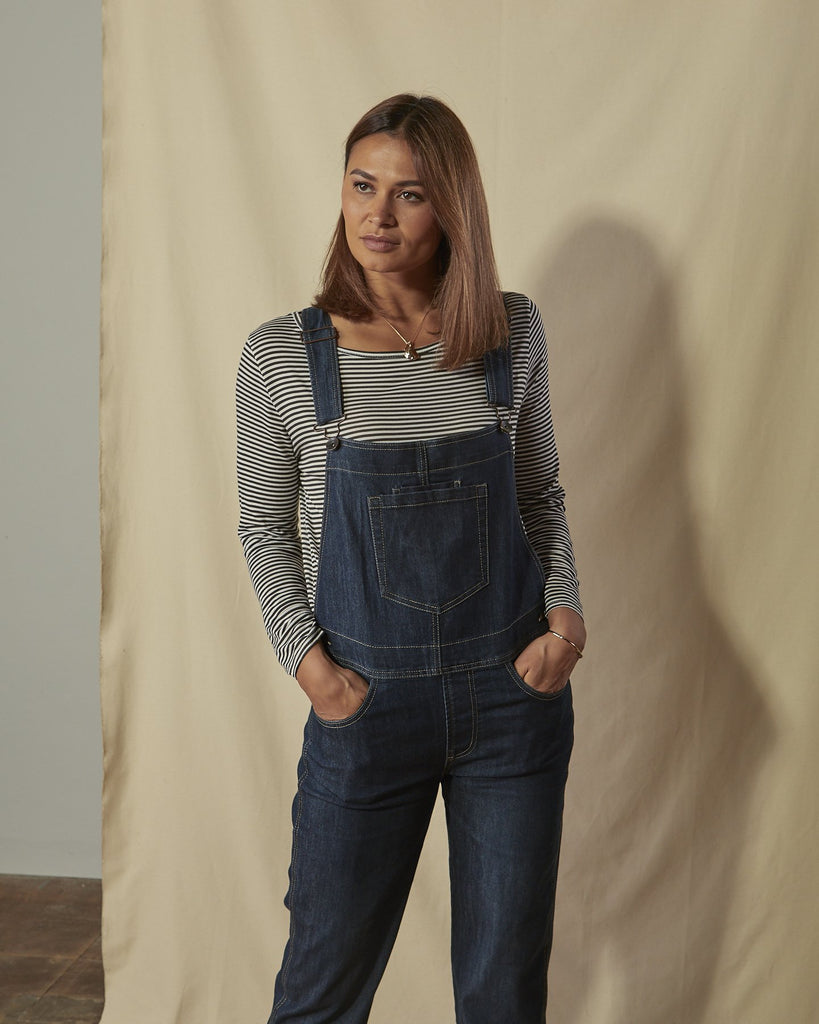 Two-thirds length front shot of model with hands in front pockets of Dottie dark-wash ladies regular fit dungarees.
