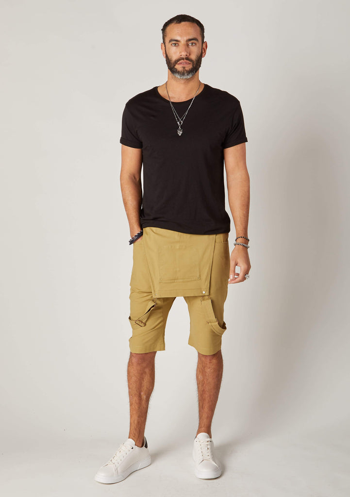 Full frontal bib-down view of slim-fit, khaki cotton bib-overall shorts from Dungarees Online, with hand in front-right pocket.