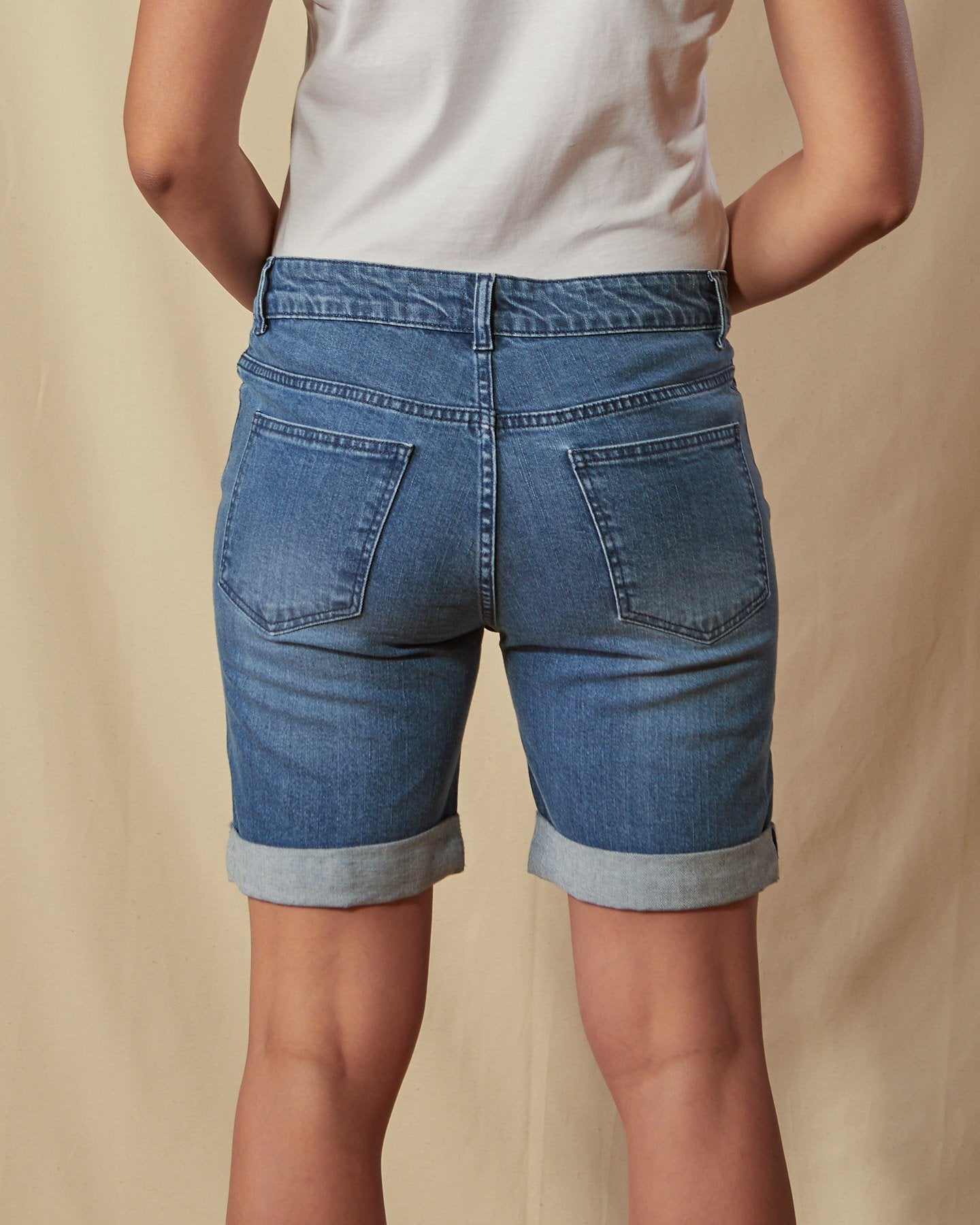 Close-up back view of blue denim Enya shorts focussing on denim texture and stitch detailing.