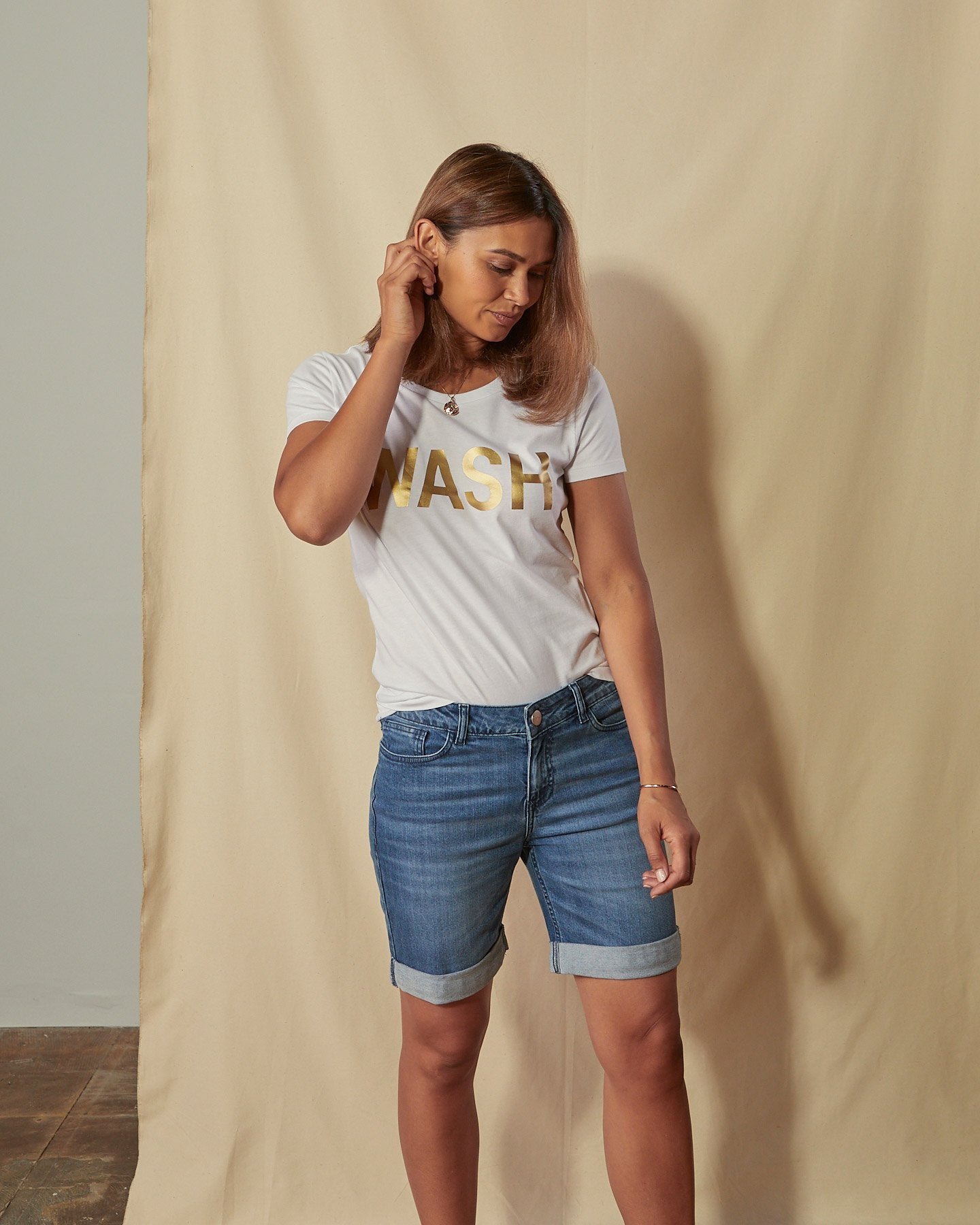 Three-quarter length front view of Enya denim shorts with view of button fastening, zip fly and multiple front pockets