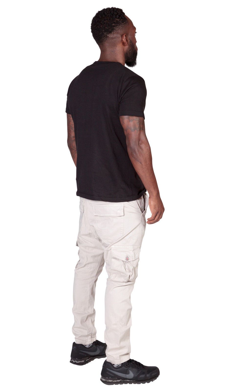 Full angled back-view wearing stone, cotton-mix combat trousers with clear view of cargo pockets.