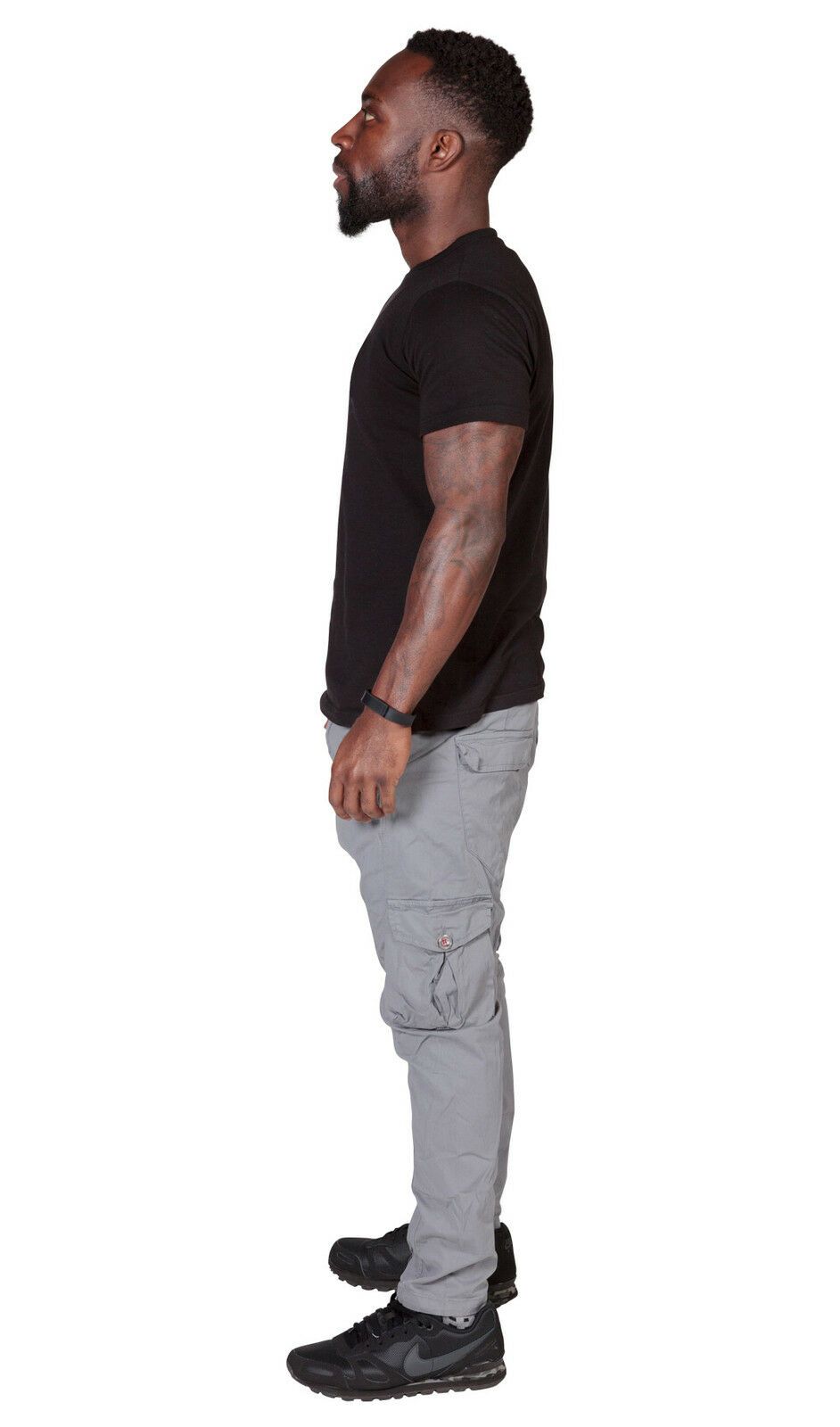 Full side view wearing grey, cotton-mix combat trousers with clear view of cargo pockets.