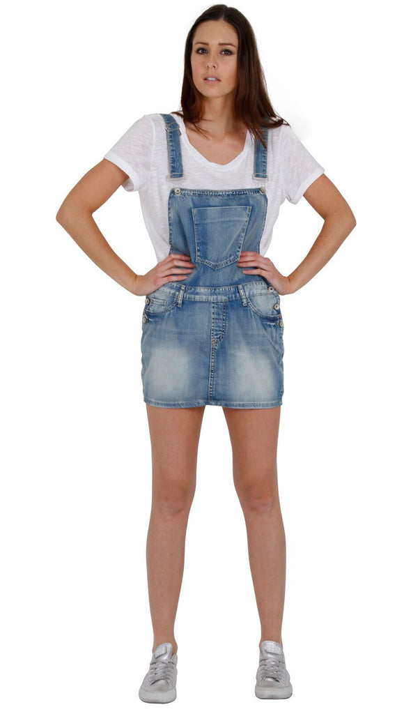 Full-length front view of stylish, ultra-short, faded blue denim dress from Dungarees Online. Model with hands on hips.