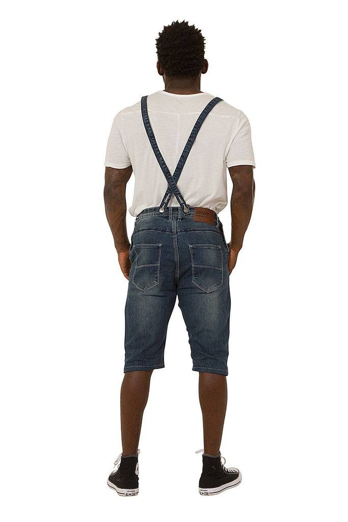 Full back pose showing rear pockets and adjustable straps of blue dungaree shorts.