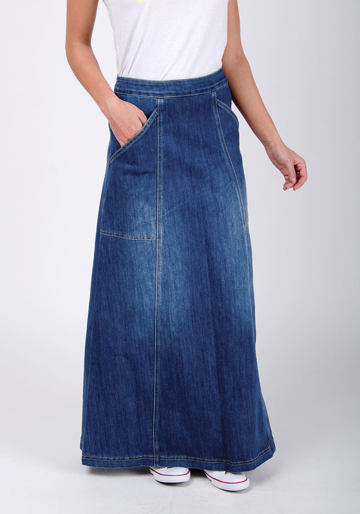 Close-up front view of long denim skirt showing panels and front pockets.