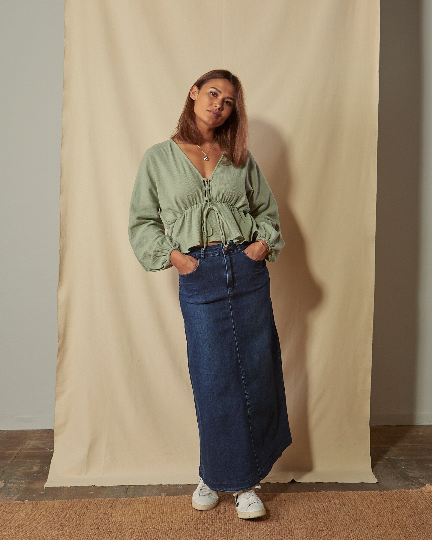 Full-length back view of Kingsley flared long denim showing figure-hugging stretch denim and ankle length hem with no back split.