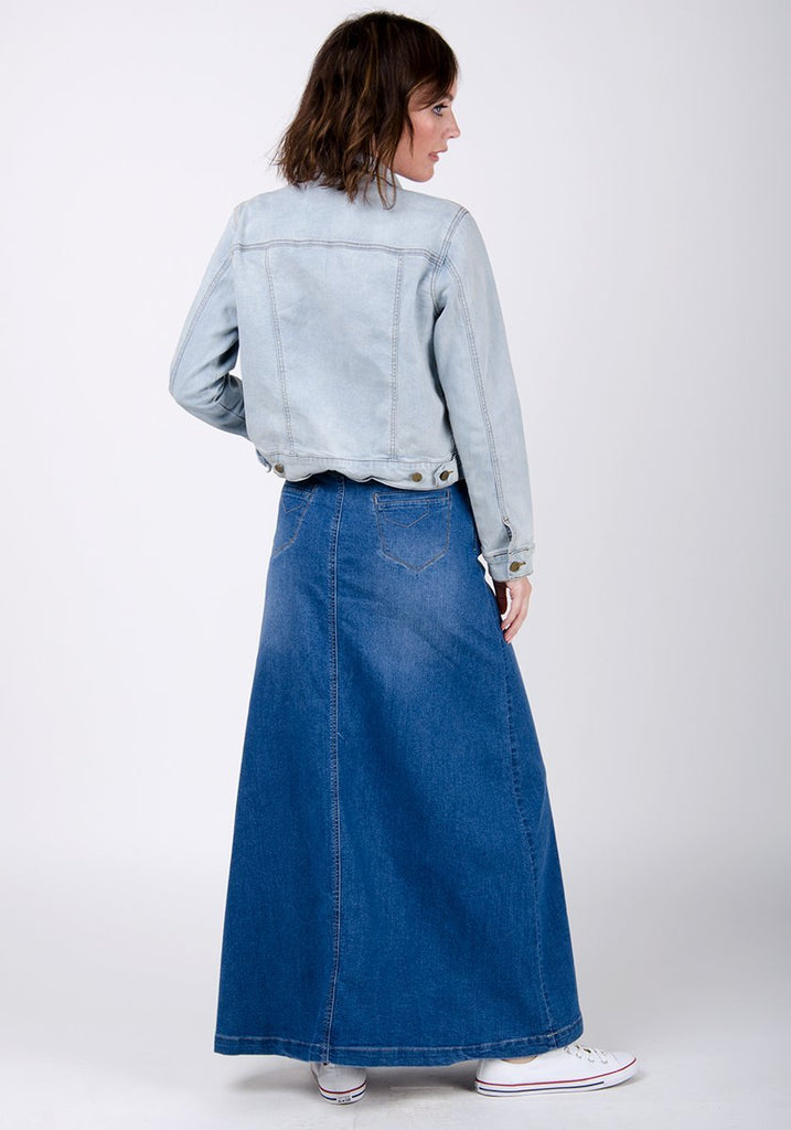 Full-length back view of stonewash flared style skirt accentuating stretch properties of denim and view of back pockets.
