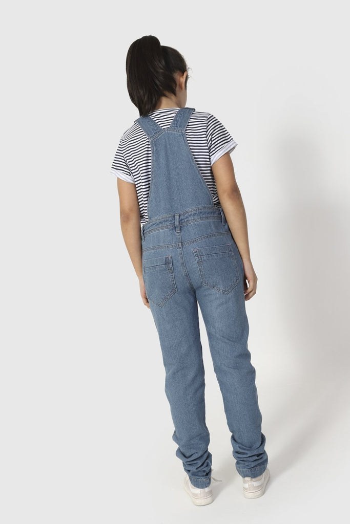 Full length, slightly angled back view of palewash denim, active kids dungarees.