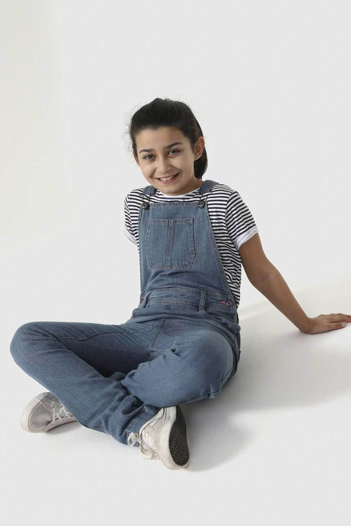 Sat cross-legged on floor wearing modern, machine washable dungarees.