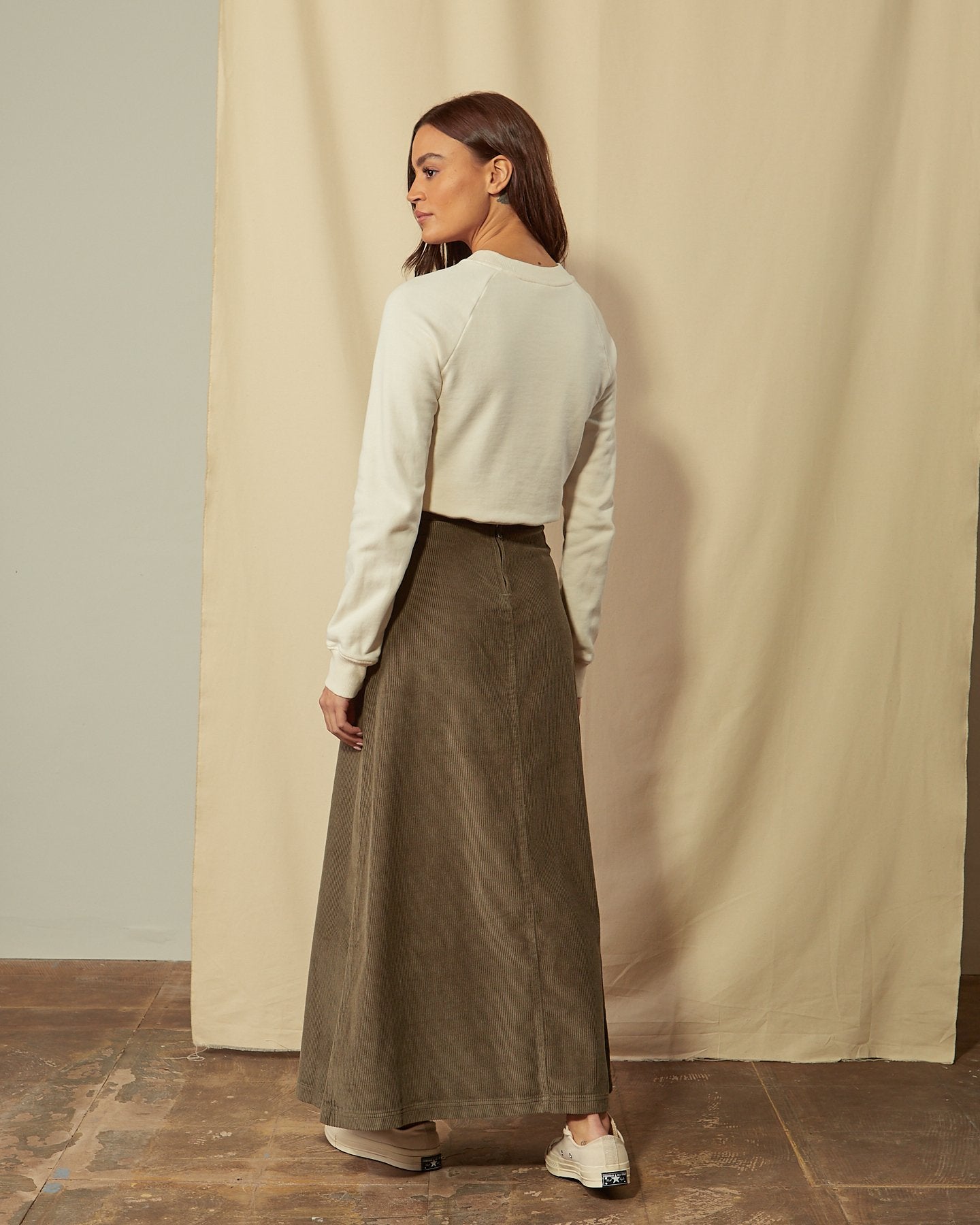 Full-length angled back view of Lottie olive-green cord maxi-skirt showing back zip.