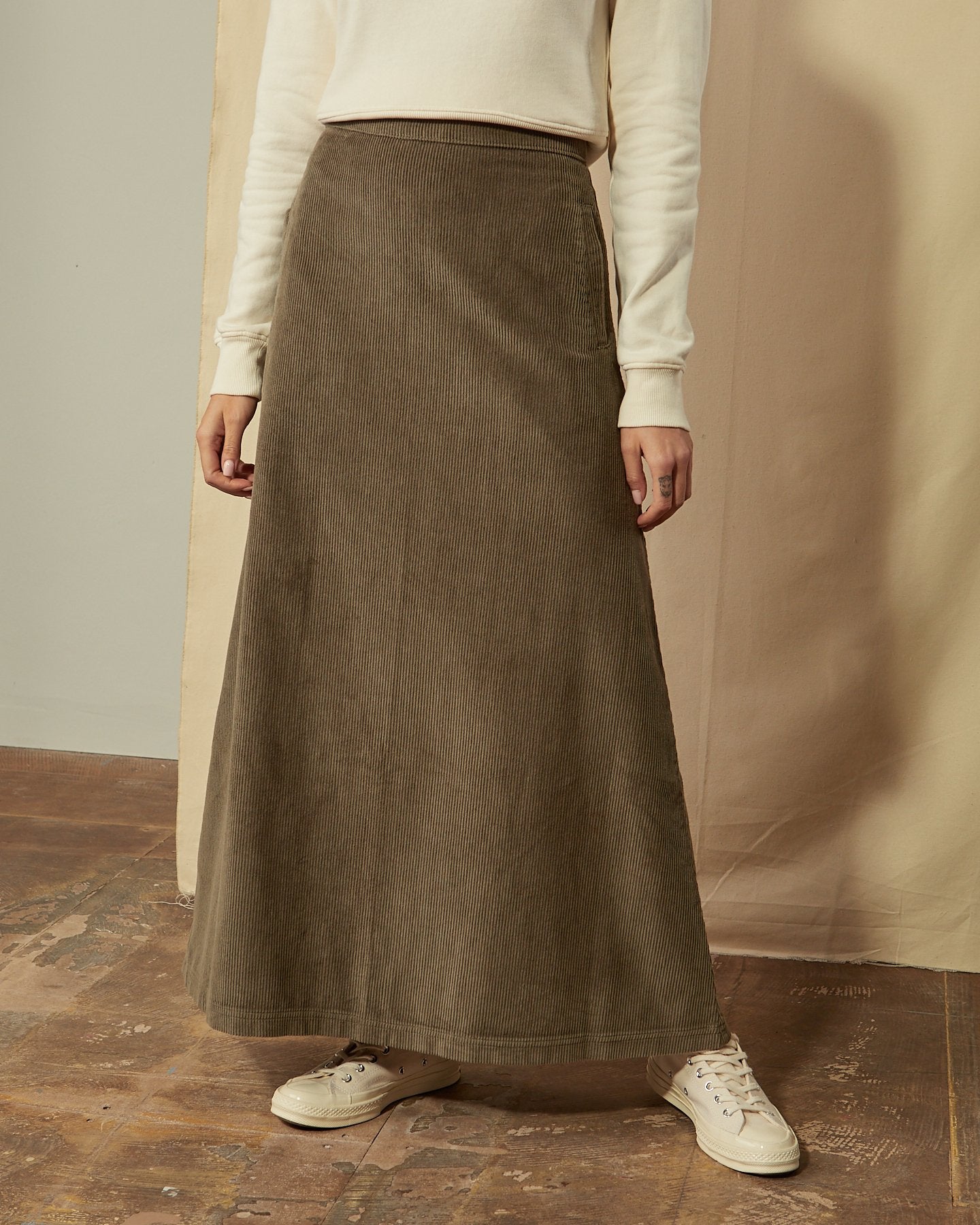 Close-up of Lottie olive-green corduroy full length skirt with clear view of cord fabric ridges.