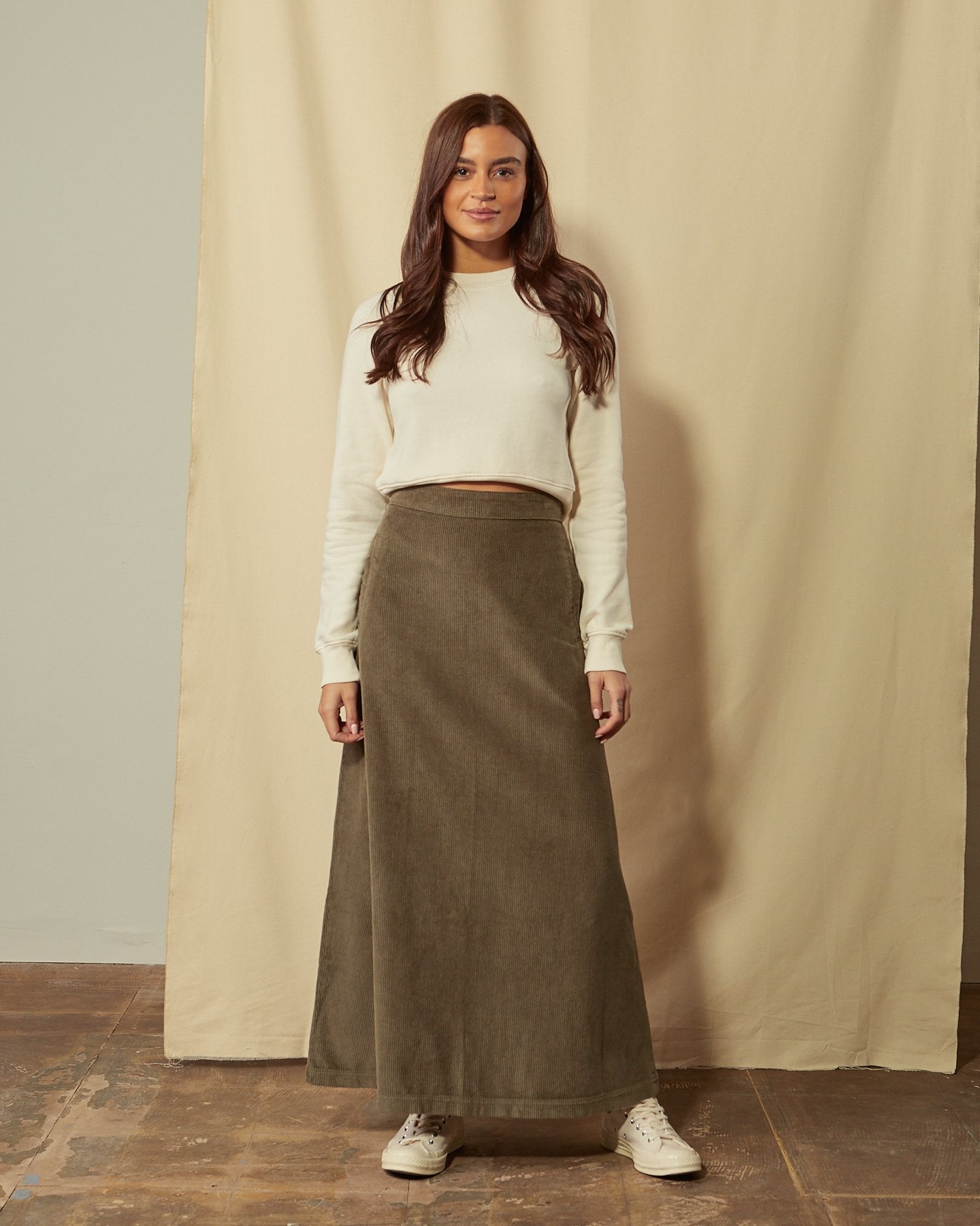 Full-length front view of model wearing Lottie olive-green corduroy maxi-skirt demonstrating A-line silhouette.