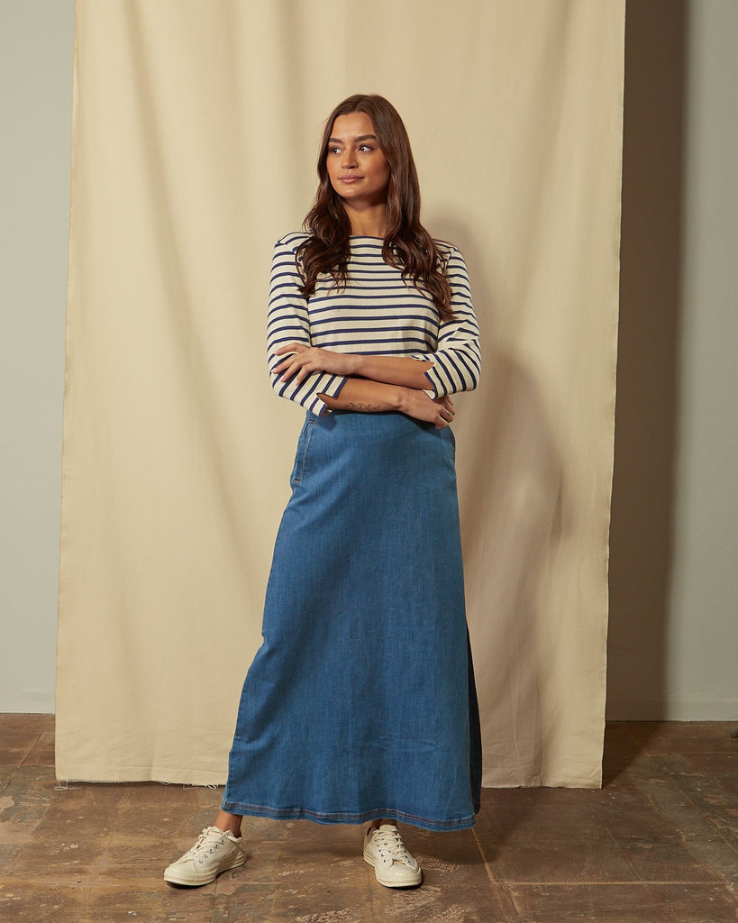 Full-length front view of model with arms folded wearing Lottie palewash denim maxi-skirt.