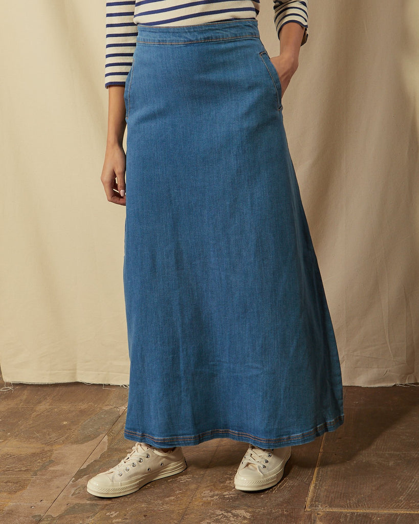 Angled close-up of Lottie palewash maxi-skirt with hand in front pocket.
