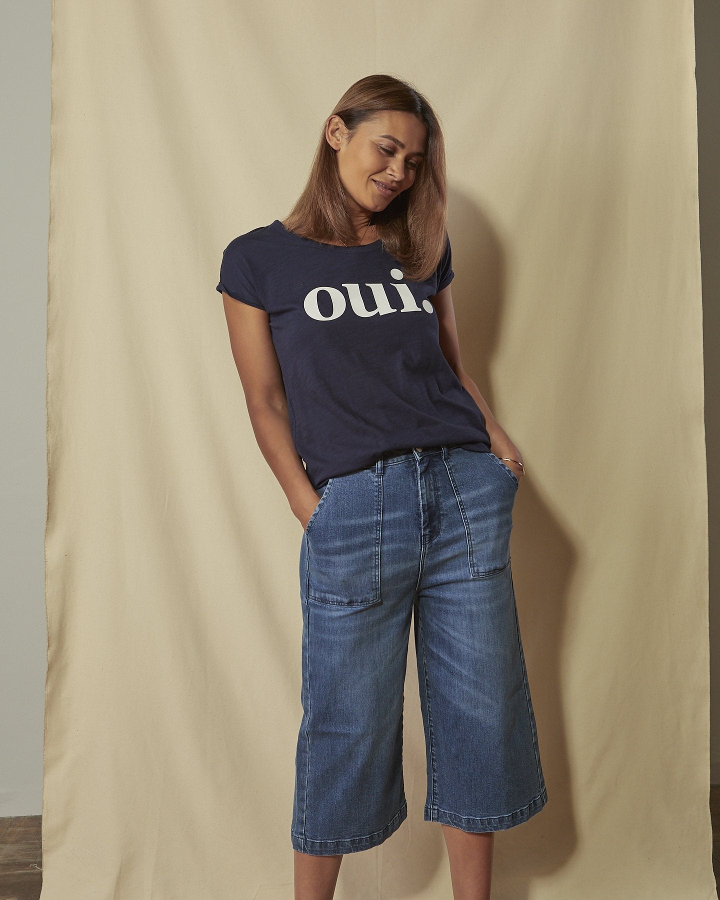 Close front view women's denim culottes showing large front pockets, fly zip and belt loops.