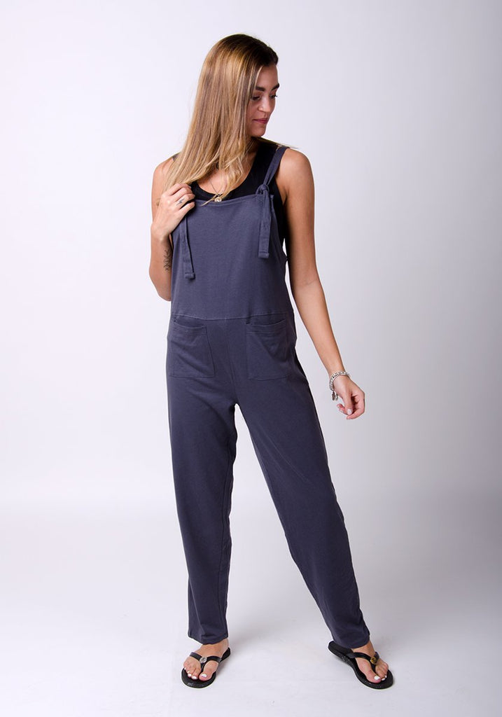 Full frontal pose with weight on right leg, wearing practical charcoal jersey jumpsuit.